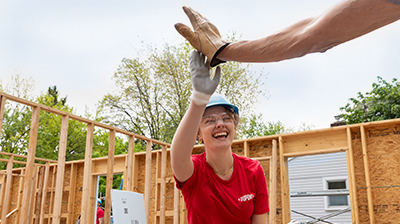 A-Hand-Up Habitat team members high-fiving at a home construction site