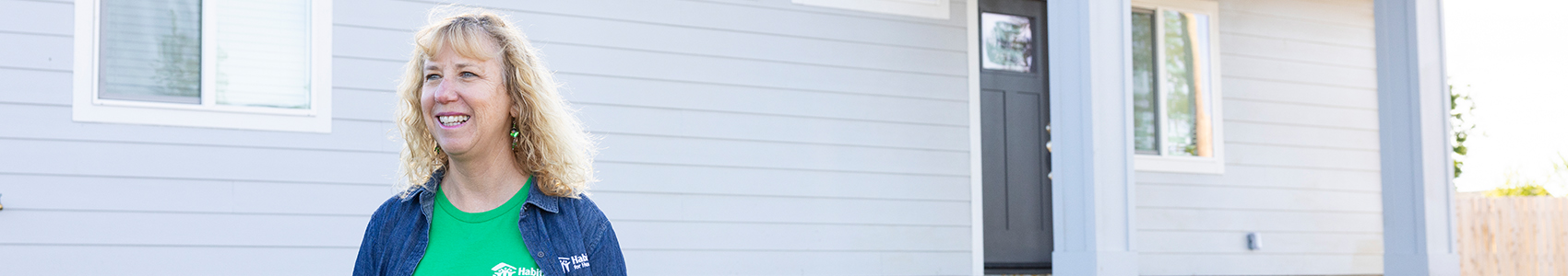 Volunteer standing outside of a house